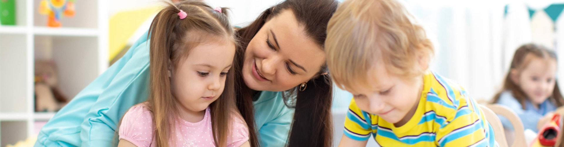 preschool children and kindergarten teacher playing with wooden toys